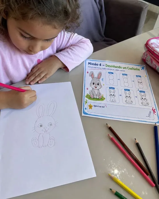 Menina desenhando um coelhinho com a lição passo a passo